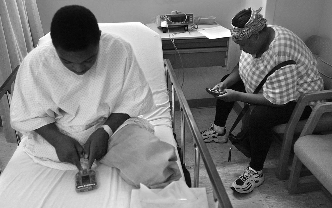 First Place, Ohio Understanding Award - Ed Suba, Jr. / Akron Beacon JournalTrying to find ways to battle the boredom of the endless waiting during constant hospitals stays, Leroy Sutton (l) and mother, Katrina (right) play video games while he waits to undergo another surgical procedure to remove scar tissue on his below-the-knee amputation at Akron Children's Hospital.