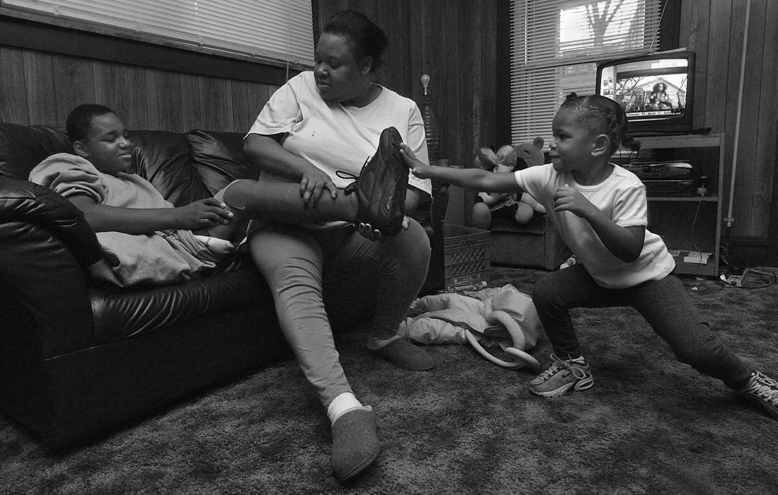 First Place, Ohio Understanding Award - Ed Suba, Jr. / Akron Beacon JournalLeroy Sutton's rehabilitation road is a family affair as his mother, Katrina and sister, Keyaira, pitch in to help him put on the first of his artificial legs while at home.