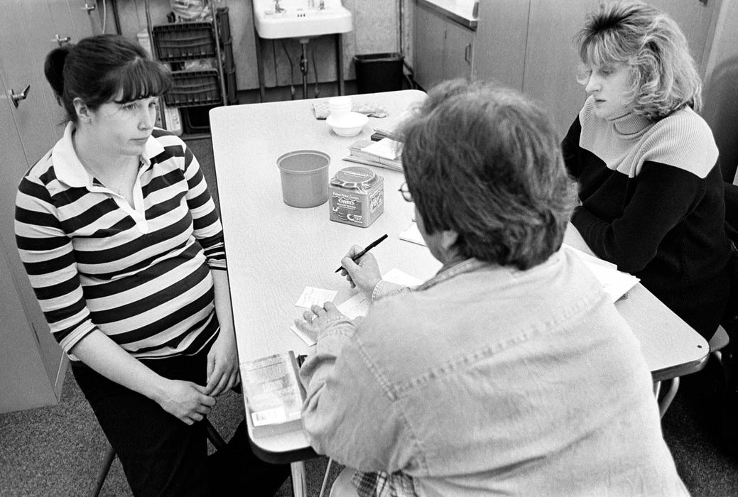 Second Place, Ohio Understanding Award - James M. Patterson / Ohio UniversityHeather Green, seven months pregnant, is interviewed by W.I.C. (Women Infants and Children) employees, dietician Treva Lambert (right), and nurse Pat Leslie (center). W.I.C. provides nutritious food, breastfeeding support and education to GRADS students at school so they don't have to miss class for appointments. 