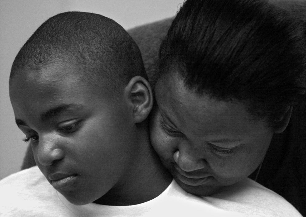 First Place, Ohio Understanding Award - Ed Suba, Jr. / Akron Beacon JournalA single mother of four, Katrina Sutton, now even more the center of her injured son's life,  hugs Leroy while a doctor examines how well his stumps are healing in the burn unit at Akron Children's Hospital.