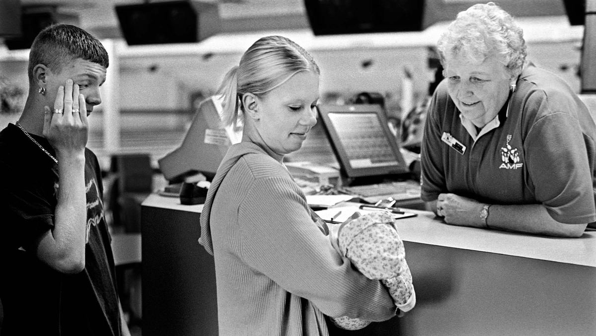 Second Place, Ohio Understanding Award - James M. Patterson / Ohio University While visiting her parents’ bowling league, Alissa presents her daughter to Mary Dwiggins. During the first week after Madison’s birth she received a steady stream visitors and gifts from admiring relatives and friends.