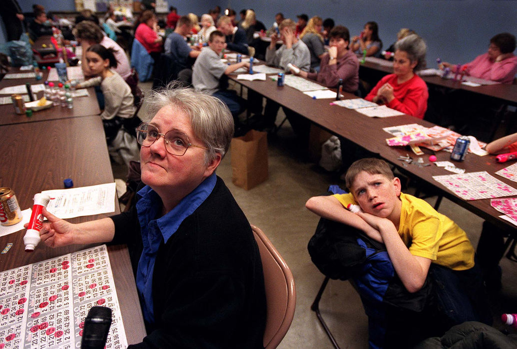 Third Place, Ohio Understanding Award - Steven M. Herppich / Cincinnati EnquirerShortly after 7 pm each Thursday night, the St. Boniface School cafeteria in Northside, a neighborhood in Cincinnati, is packed with nearly 200 people. The people that are here each week come to unwind-and win! Peggy Gillen, of Miamitown, looks for the next number to be called as Danny Loveless, 11, of Camp Washington, watches the tv monitor in the non-smoking room at Saint Boniface Church in Northside, January 17, 2002.  