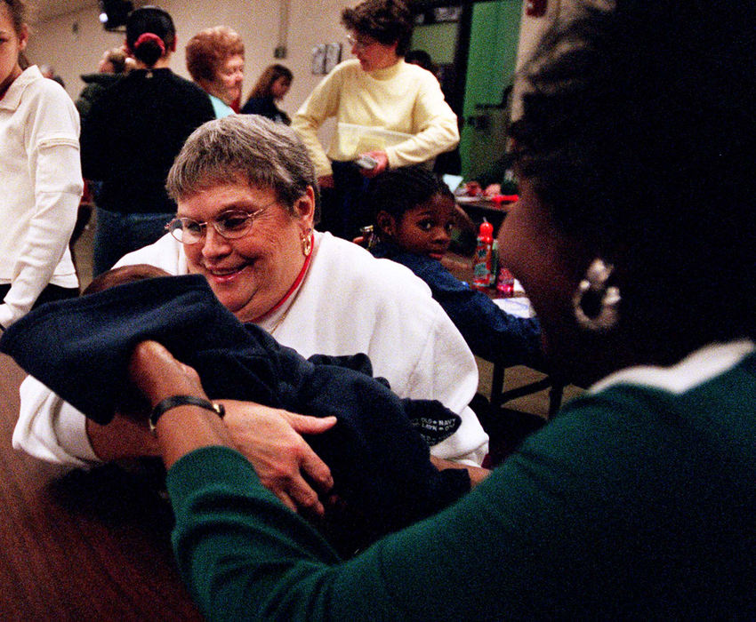 Third Place, Ohio Understanding Award - Steven M. Herppich / Cincinnati EnquirerShirley Phillips, of Western Hills, holds 13-day-old Lorenzo Campbell at St. Boniface Bingo in Northside, January 17, 2002. Lorenzo's mother, Tammy (not pictured), only had to miss one bingo week to have her son, but brought the baby to show off to friends as soon as she was able. 