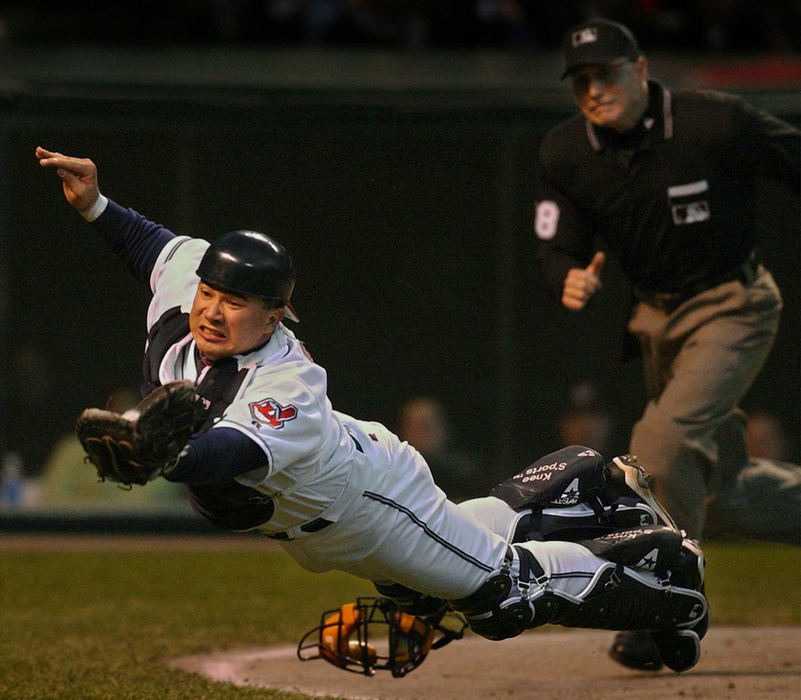 First Place, Photographer of the Year - Ed Suba, Jr. / Akron Beacon JournalCleveland catcher Einar Diaz makes a diving catch of a foul pop off the bat of Baltimore's second baseman Jerry Hairston during fourth inning action in the Indians game against the Orioles at Jacobs Field in Cleveland. Home plate umpire Dan Iassogna watches at the right. 