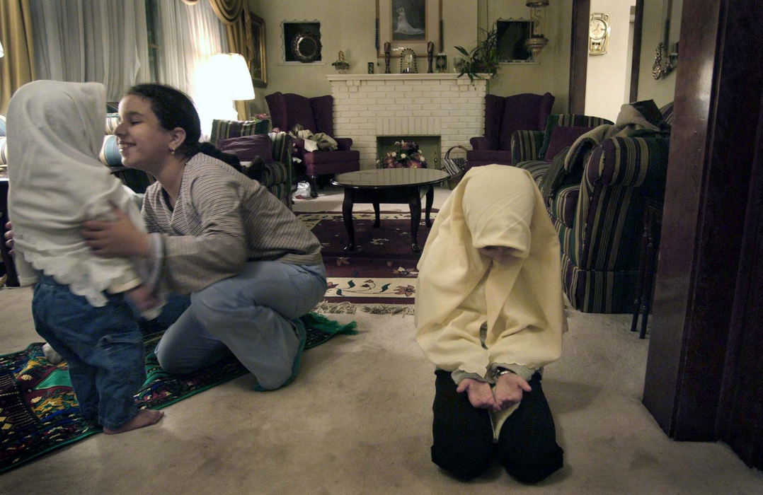 Third Place, Photographer of the Year - Dale Omori / The Plain DealerZena Assaad plays with sister Hanna as Lena finishes sundown prayers in their Lakewood, Ohio home on the first day of the Muslim holiday, Ramadan. 