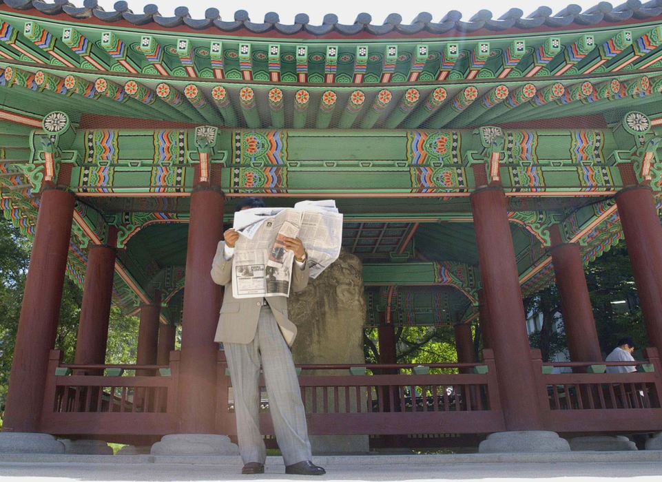 Award of Excellence, Photographer of the Year - Amy Sancetta / Associated PressA businessman reads the morning paper under the shadow of a shrine at Tapgol Park in Seoul, South Korea on June 25, 2002.  A peaceful respite in the bustling city, the park is dotted with towering shade trees and a number of historic structures and statues. 