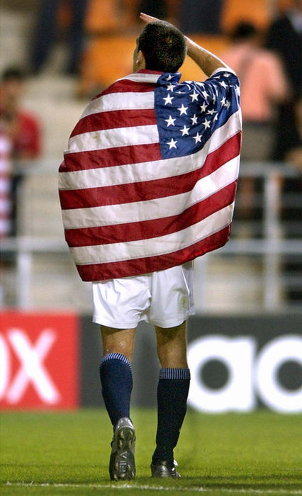 Award of Excellence, Photographer of the Year - Amy Sancetta / Associated PressUSA captain Claudio Reyna waves to the crowd as he walks of the field wrapped in an American flag after the US team lost its quarterfinal match to Germany at the 2002 World Cup quarterfinal soccer match in Ulsan, South Korea on June 21, 2002. The game dropped the US from the competition. 