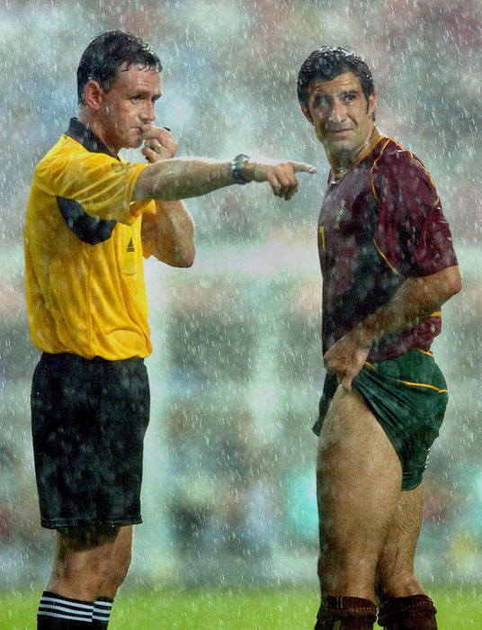 Award of Excellence, Photographer of the Year - Amy Sancetta / Associated PressReferee Hugh Dallas of Scotland (left) gestures past Portugal striker Luis Figo under heavy rain during the 2002 World Cup Group D soccer match between Poland and Portugal at the Jeonju World Cup stadium in Jeonju, South Korea, June 10, 2002.