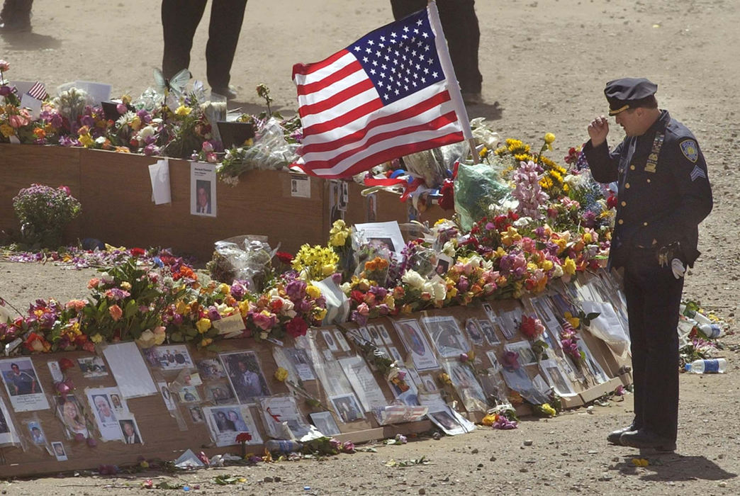 Award of Excellence, Photographer of the Year - Amy Sancetta / Associated PressA police officer pays his respects at the ring of remembrances at ground zero during the ceremony marking the one year anniversary of the attacks on the World Trade Center in New York on Sept. 11, 2002. 