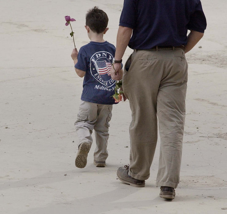 Award of Excellence, Photographer of the Year - Amy Sancetta / Associated PressA young boy and a man carry flowers in the footprint of the World Trade Center towers during ceremonies  marking the one year anniversary of the attacks at ground zero in New York on Sept. 11, 2002.