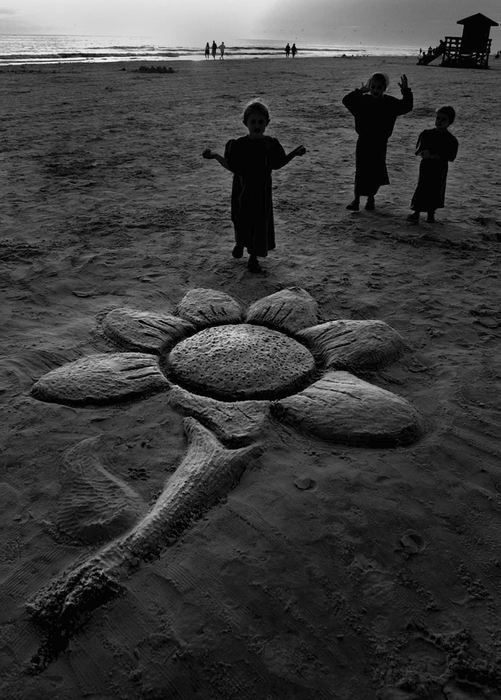 Award of Excellence, Photographer of the Year - Michael E. Keating / Cincinnati EnquirerThree Mennonite girls return to their sand sculpture to add finishing touches.