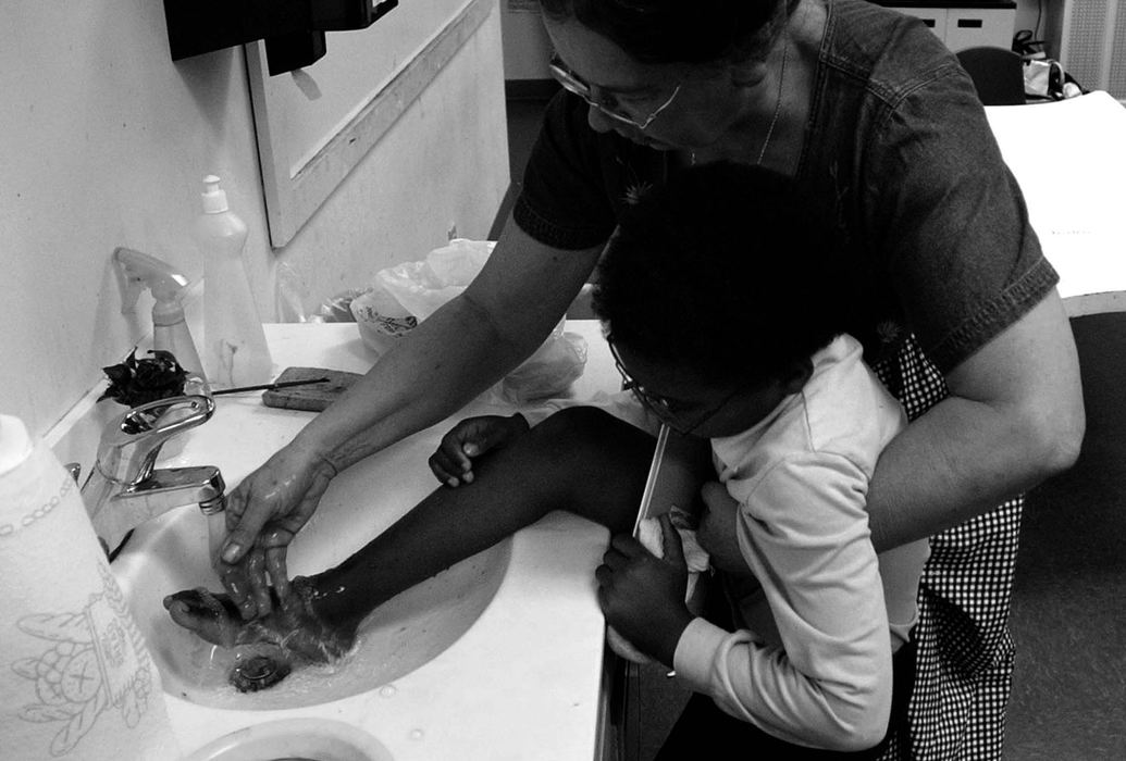 Award of Excellence, Photographer of the Year - Michael E. Keating / Cincinnati EnquirerTeacher Nancy Bitter uses cool water to soothe the "itchy" foot of student Karim Laury. It was believed to be a bug bite. It was distracting Karim and Ms. Bitter's attentiveness seemed to lessen his distraction. 