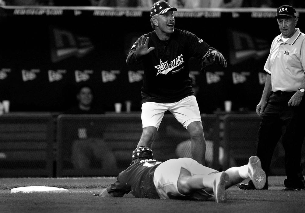 Award of Excellence, Photographer of the Year - Michael E. Keating / Cincinnati EnquirerFormer teammate Mike Schmidt, playing third base in the celebrity softball game, breaks into a smile as Pete Rose falls short while attempting  his trademark head first slide in the base.