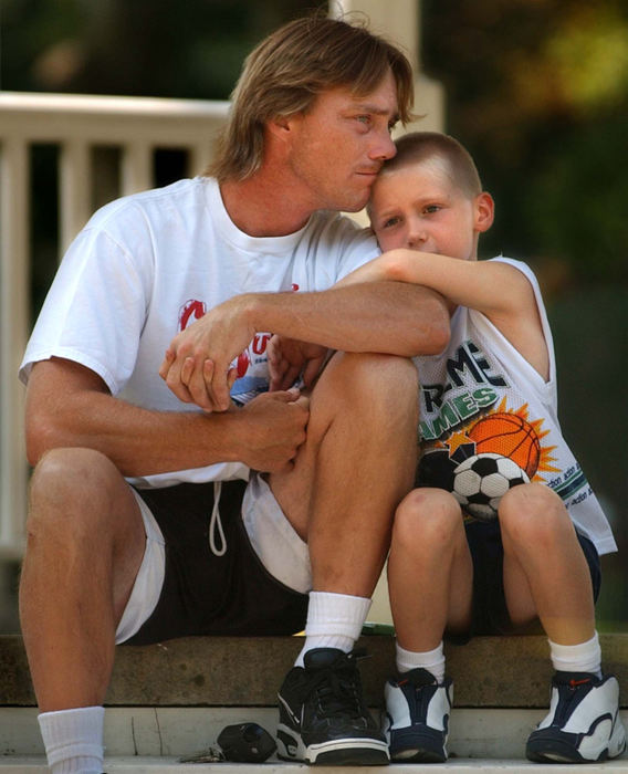 First Place, Photographer of the Year - Ed Suba, Jr. / Akron Beacon JournalAnthony C. Mignano sits with his eight-year-old son, Anthony F. Mignano. The eight-year-old boy, who had previously run away from his foster care family in Twinsburg after stealing a truck because he missed his father, ran away for a second time, this time on foot, to be with his father again. 