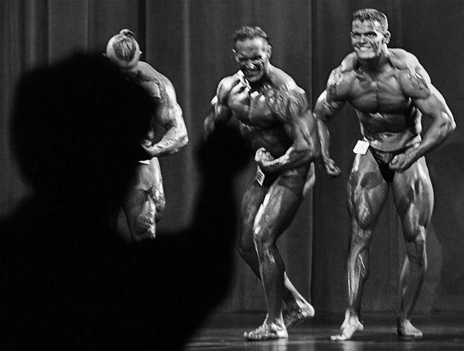 First Place, Photographer of the Year - Ed Suba, Jr. / Akron Beacon JournalAs an enthusiastic fan cheers him on, Akron firefighter Doug Price (right,) having won the light heavyweight division of the 2002 Canton Bodybuilding championship, competes in the final pose-down against the other divisions winners onstage at Timken H.S. in Canton. Price won the competition.