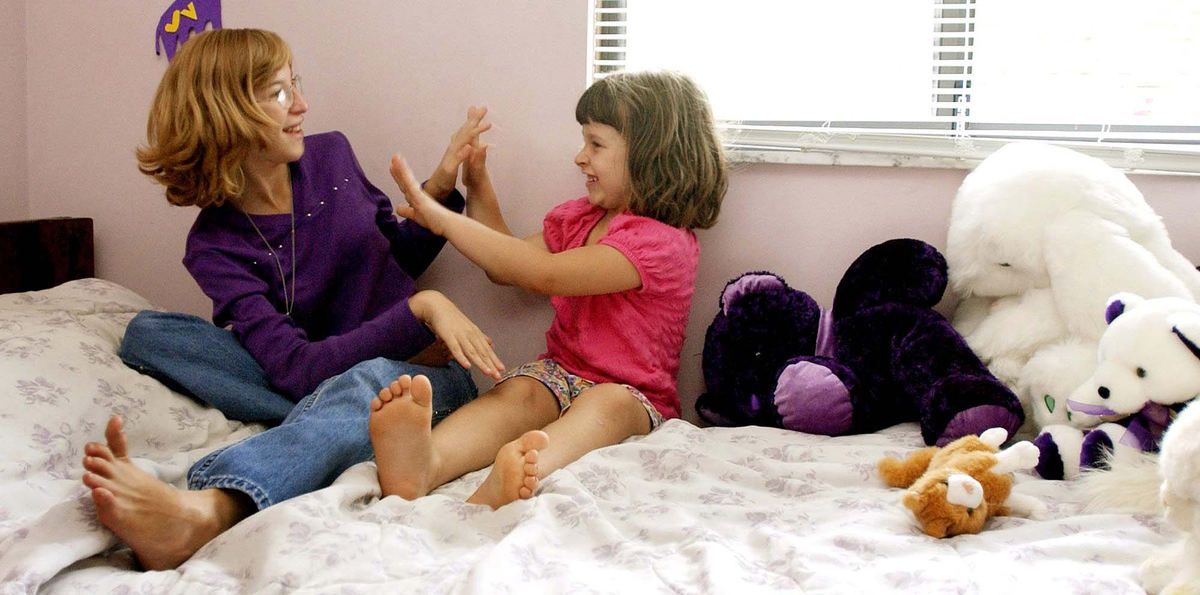 Second Place, Photographer of the Year - John Kuntz / The Plain DealerJennifer Vinkler,13, of Mentor-on-the Lake (left) plays with her 5 year-old friend Carley Loporto who lives down the street in Jennifer's bedroom September 18, 2002 before her brain surgery to implant electrodes to decipher whether she will be a candidate for brain removal surgery to cure her epilepsy episodes.  Jennifer's mental capacity has deteriorated because of her frequent seizures and relates to the younger Carley than kids her age.  