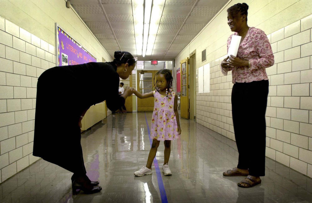 Third Place, Photographer of the Year - Dale Omori / The Plain DealerCleveland Schools Superintendent Barbara Byrd-Bennett introduces herself to Grace Nicole White, 4, as her mother, Barbara White, looks on Aug. 29, 2002 in Cleveland.  Grace was touring Daniel E. Morgan Elementary School with her mother and will take the placement test to enter the Child Development Class for 4 year olds which begins in September.  