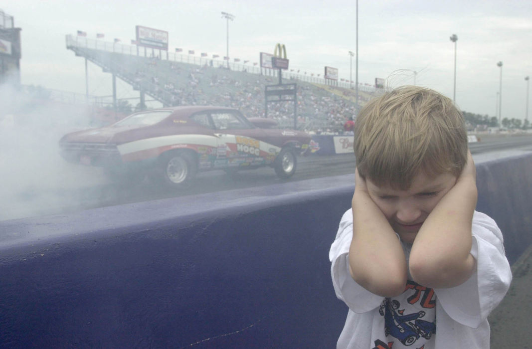 Award of Excellence, Sports Feature - David Distelhorst / The AdvocateCody Kershaw, 5, of Erie Pennsylvania covers his ears from the sound of a car making its way down the track at Norwalk, July 7, 2002. His father, James Kershaw, raced in the Bracket One race at the Super Chevy Show.