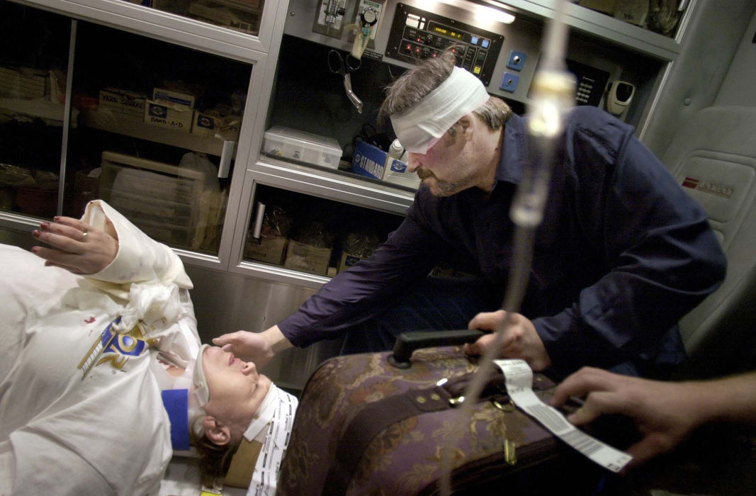 First Place, Spot News over 100,000 - Dipti Vaidya / The Columbus DispatchBruce Ward caresses his injured wife Pam's cheek while holding their luggage from a trip to Las Vegas in a medic truck. He and his wife were on the way back from their vacation when they were injured in a multi-car wreck.  Bruce said he was mainly concerned about his wife, who had hit the windshield on impact. 