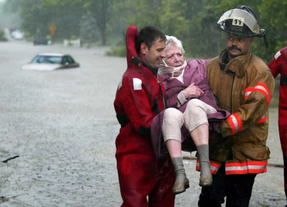 Award of Excellence, Spot News over 100,000 - Chris Russell / The Columbus Dispatch Columbus firefighters help Mary O'Leary to dry land after rescuing her from her car which was flooded along Eatmoor Blvd in Columbus. 