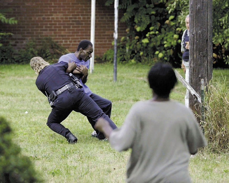 Second Place, Spot News under 100,000 - Dave Polcyn / The News JournalA Police Officer tackles a man after he crossed police lines during a standoff on Mulberry Street. The police were looking to serve a warrant on Danny Brown. His mother in the foreground is also rushing toward the back of the house where Brown was supposed to be holed up. It was determined that no one was in the house.