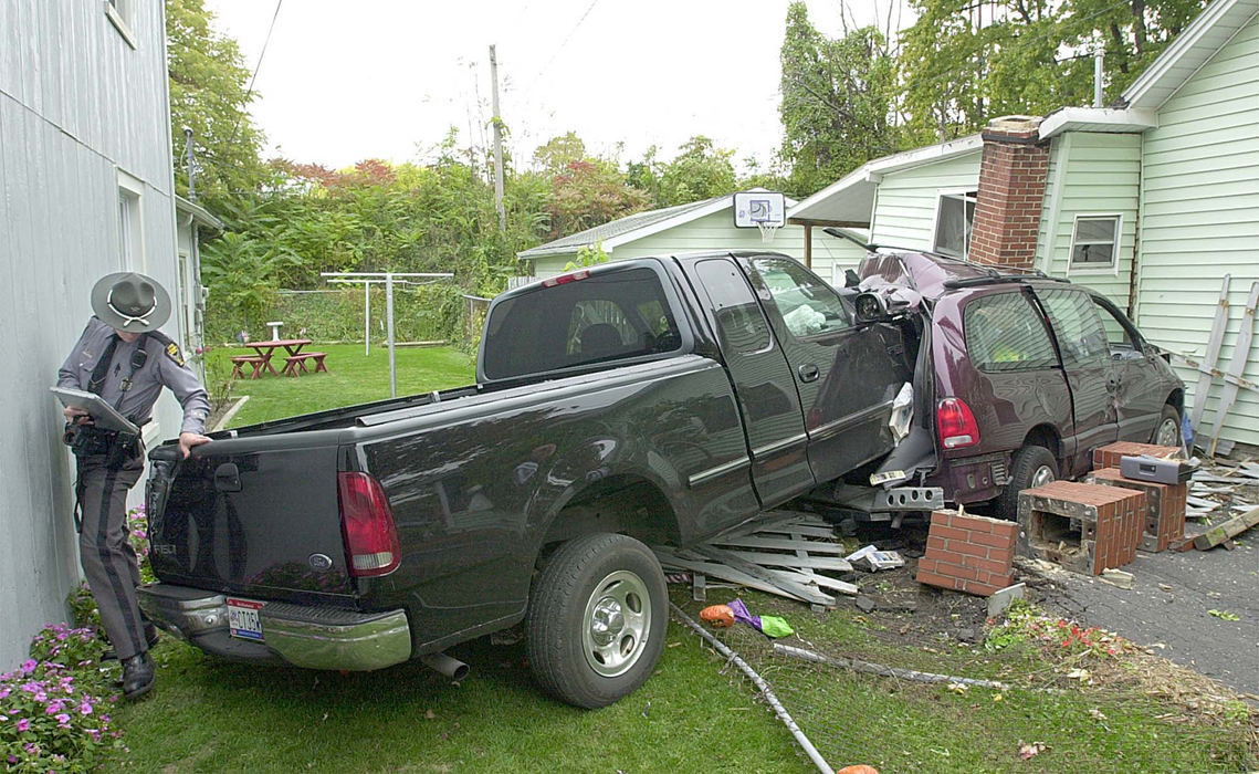 Award of Excellence, Spot News under 100,000 - Jason Werling / Sandusky RegisterOhio Highway Patrolman Shane Zender makes his way around a pickup that slammed into Kim and Todd Taylor's minivan on E. 3rd Street in Port Clinton. The truck pushed the van into the house, pushing part of the house off of its foundation, knocking over a brick chimney and causing a suspected gas leak.