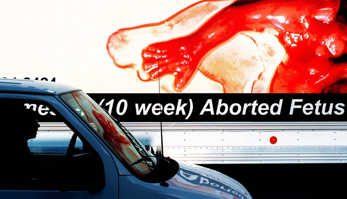 First Place, Student Photographer of the Year - James Patterson / Ohio UniversityRon Stacey, parked in his van on Main Street, watches as the Reproductive "Choice" Campaign truck drives by. Billboard size images of aborted human embryos and fetuses were depicted on the sides and rear of the truck, which drove on Findlay streets throughout the day.