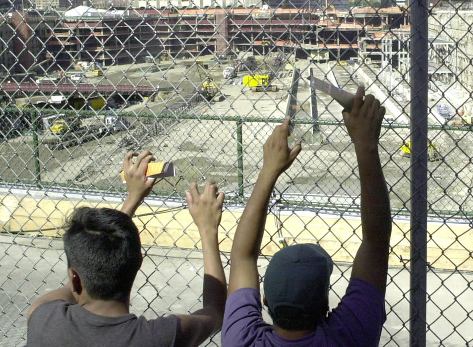 Second Place, Student Photographer of the Year - David Distelhorst / Ohio UniversityDaniel Amirez (left) and Eleazar Nunez, of New York City, hang on a fence around Ground Zero to get a glance of the empty pit left behind one year after the destruction of the World Trade Center's Twin Towers, September 9, 2002.