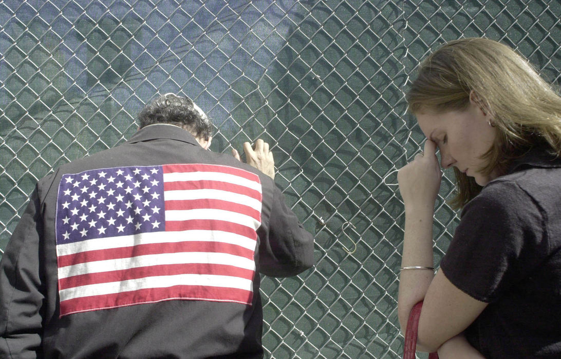 Second Place, Student Photographer of the Year - David Distelhorst / Ohio UniversityOutside a gate to Ground Zero Randy Garon (left) and Catherine Gill Knudsen listen to the reading of the names of the victims of Sept. 11 on the one year anniversary of the attacks.