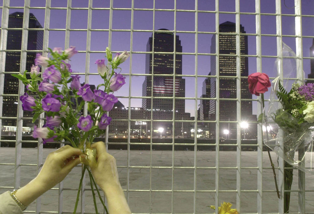 Second Place, Student Photographer of the Year - David Distelhorst / Ohio UniversityAs the sunsets on September 11, 2002, Marianna Dryl of Poland ties flowers to a fence overlooking the former site of the World Trade Center. 