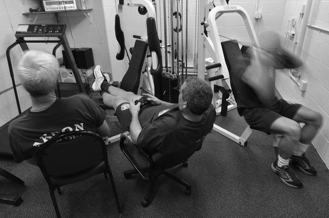 First Place, Sports Picture Story - Ed Suba, Jr. / Akron Beacon JournalTraining continues even at work. Two Akron firefighters play a video game as Doug Price does a cardio workout while on call at the station. The aerobic workouts help Price drop body fat and lets the muscle definition stand out against the skin. Price is a bodybuilder who has been training for the last year preparing for the 2002 Canton Bodybuilding competition. It will be Price's first contest and he will be competing against bodybuilders from all over the state of Ohio.