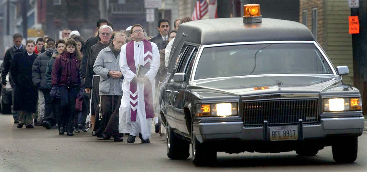 Second Place, Team Picture Story - Dale Omori / The Plain DealerThe procession for slain priest. William Gulas marches north on E. 65th St. to St. Stanislaus Catholic Church.