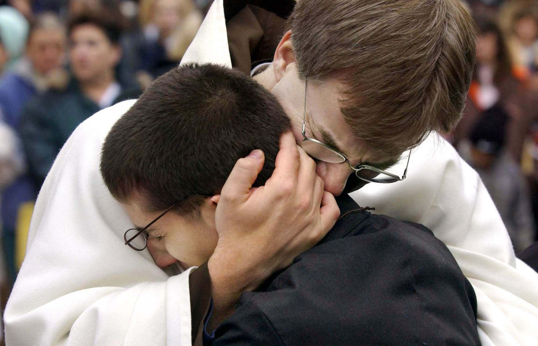 Second Place, Team Picture Story - Joshua Gunter / The Plain DealerRev. Michael Surufka consoles one of the choir boys as the casket of Father William Gulas is driven away from St. Stanislaus Church.