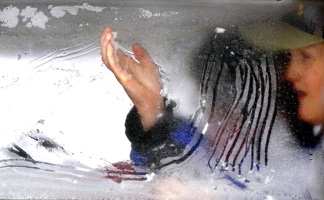 Award of Excellence, Enterprise Feature - John Kuntz / The Plain DealerA seventh grader scratches the icy condensation on the inside of the Crestwood Middle School bus outside the Cleveland Convention Center January 23, 2003 as winter temps dip to 10 degrees with wind chill factor dropping it below zero.  The school kids were waiting to exit their bus to participate in the Music Educators Association convention. 