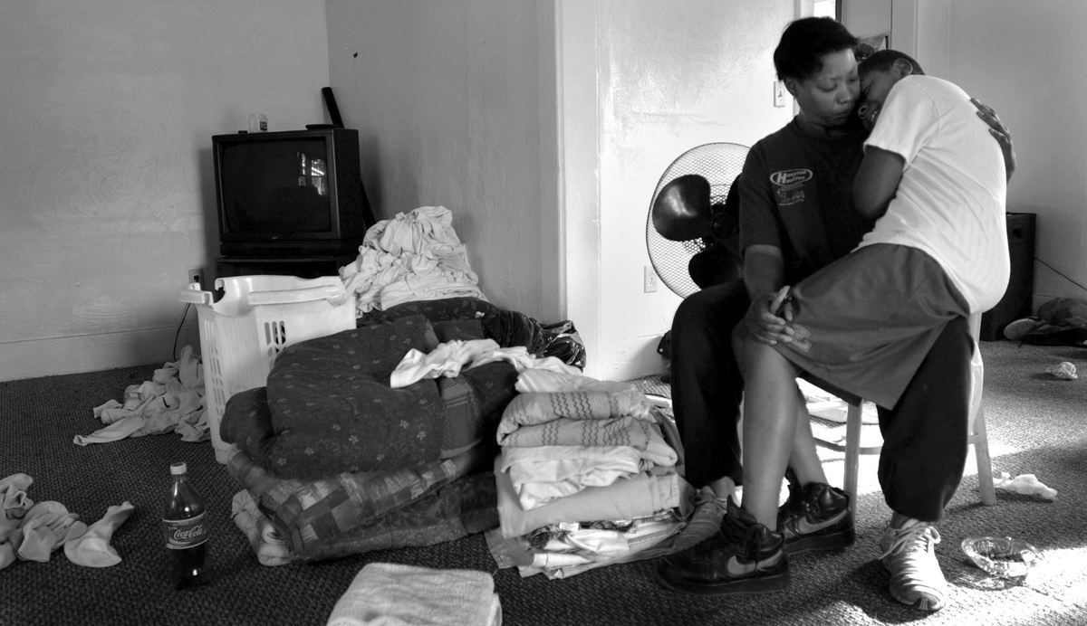 Second Place, Feature Picture Story - Dale Omori / The Plain DealerRobert takes a break on mom's lap as the family gets ready to move out of their home.  The $600-a-month rent has become too expensive for Michele Noble, forcing her and her boys to leave the home.