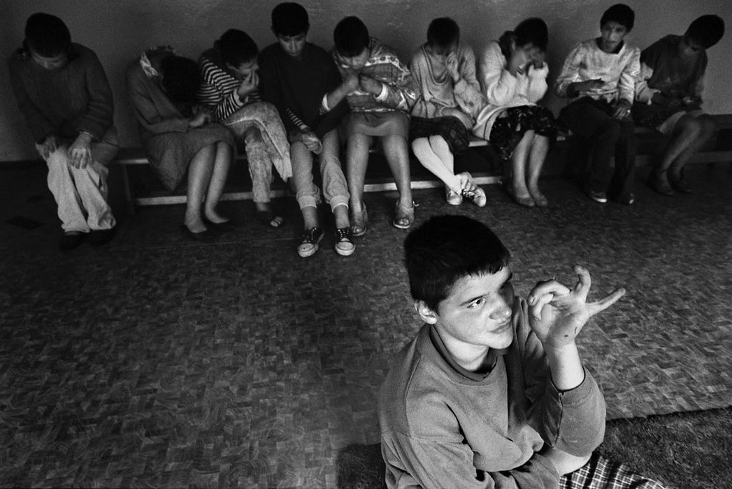 Third Place, Feature Picture Story - Greg Ruffing / FreelanceSergei, age 16, sits on the cold, hard floor as a group of other children fill up a bench, many with arms interlocked, rocking back and forth as a therapeutic routine. While some institutions are state-funded, it is often only enough to provide half of all the medication that is needed.