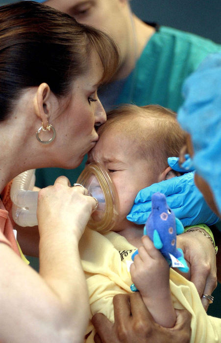 Award of Excellence, Feature Picture Story - Daniel Melograna / The News JournalIvy Ervin kisses the forehead of her son, Luke, 2, as she helps Vyas Kartha and Steve Campagna put Luke to sleep Friday, May 16, 2003 before his MRI at Children's Hospital in Columbus.