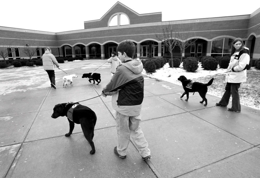 Award of Excellence, Feature Picture Story - Fred Squillante / The Columbus DispatchZach Farris, center foreground holding Frasier, joins other members of his class as they arrive at Westerville North High School. At right is one of his teachers, Amy DuBois, holding Falcon. This is one of their Friday excursions in which the Kids and Canines group take the dogs out in public. The kids made presentations to high school students. 