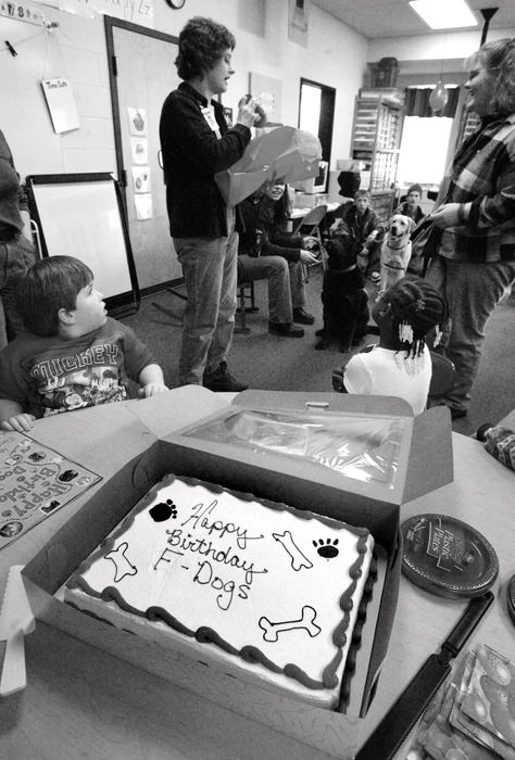 Award of Excellence, Feature Picture Story - Fred Squillante / The Columbus DispatchLea Ann Shearer of Golden Dogs Academy opens presents from Shelli Speakman's multiple handicaps class at Alcott Elementary School. The Kids and Canines participants visited the school and  celebrated the two-year anniversary of Kids and Canines program. Lea Ann Shearer provides the dogs for the Kids and Canines program and teaches the students how to train the dogs.