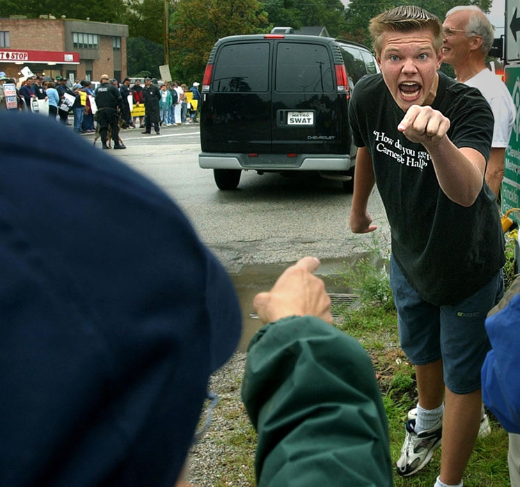 Second Place, General News - Ed Suba Jr. / Akron Beacon JournalSixteen-year-old Michael Devine, a Bush supporter, has a confrontation with a protestor while waiting for the President's motorcade to pass through Richfield. A large group of protestors and some Bush supporters stood in the rain at the intersection of Streetsboro and Broadview Roads to voice their opinions before the Presidents scheduled Labor Day speech at the International Union of Operating Engineers picnic in Richfield Township. 