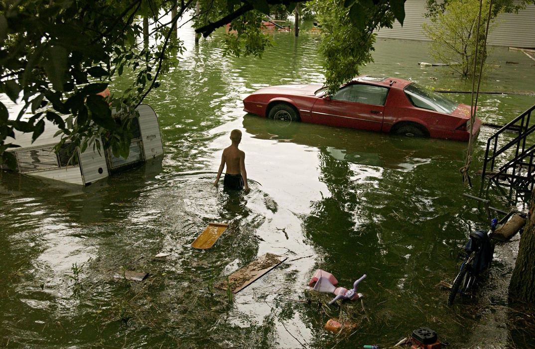 Third Place, General News - Bill Kennedy / The Plain DealerNine-year-old Austin Vogan walks through his uncles backyard on Sugar Street in Celina. The water from Grand Lake St. Mary's has overflowed with recent rain inundating parts of Celina with water.   