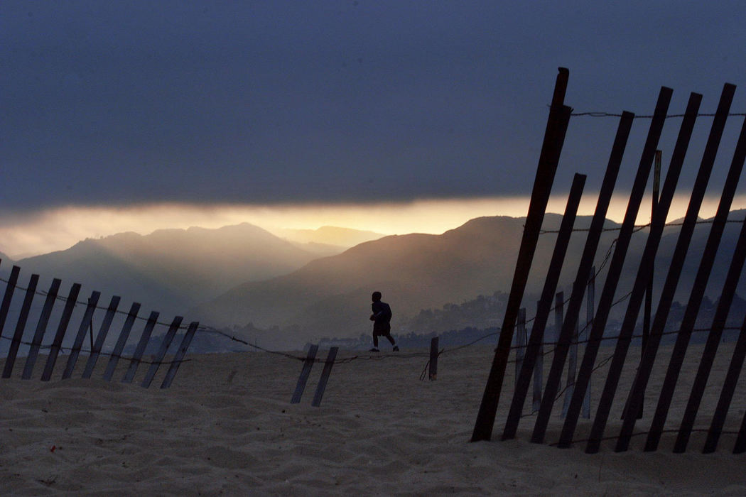 Third Place, Pictorial - Dipti Vaidya / The Columbus DispatchRoute 66 begins in Chicago and ends in the Pacific Ocean at the pier in Santa Monica California. Darrius Young,5, of Los Angeles walks along the Santa Monica Beach with a backpack selling candy for school as the sun sets against the mountains. 