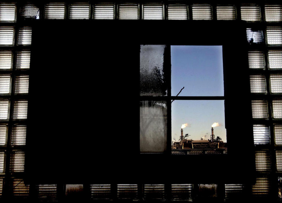 Award of Excellence, Pictorial - Chuck Crow / The Plain DealerLooking out an old window from the Master Metals site on W. 3rd St. in the industrial section of the Flats, 2 smoke stacks from LTV are in view.  This portion of the old Master Metals building will be salvaged while some of the building will have to be cleared.  The US EPA is about to start the final clean up of the former Master Metals site for the new home of Northern  Ohio Lumber and Timber Co., one of Cleveland's oldest companies.  