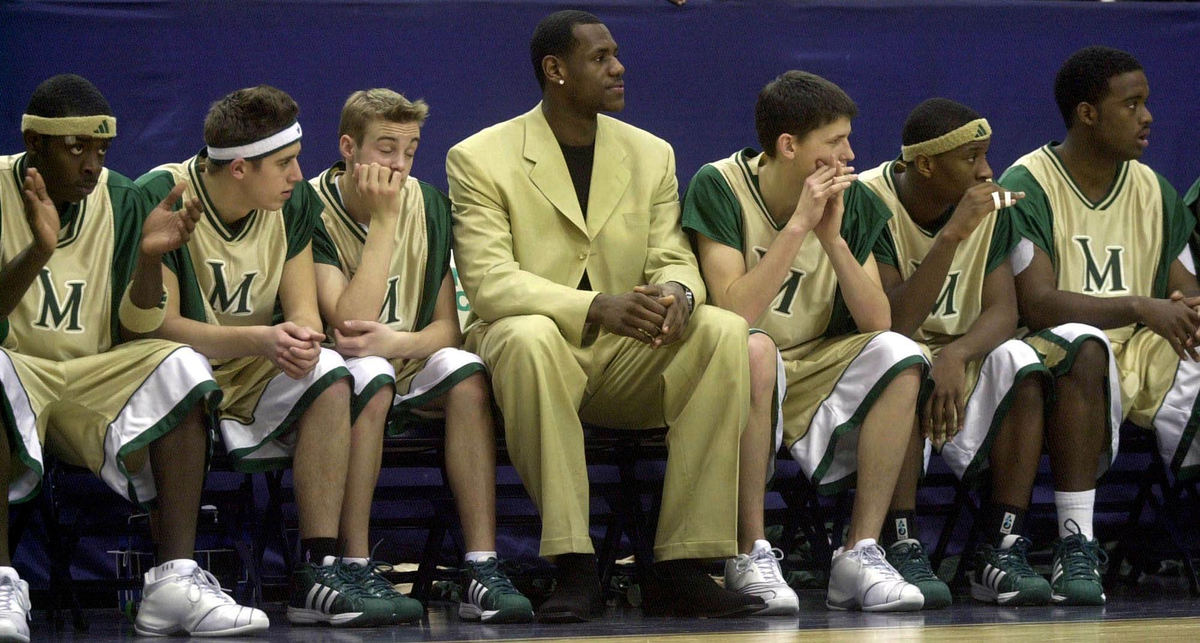 First Place, Photographer of the Year - Dale Omori / The Plain DealerAkron St. Vincent-St. Mary High School basketball star LeBron James, wearing a suit, sits on the bench during his team's game against Canton McKinley, Feb. 2, 2003, in Akron.  James was declared ineligible for the game by the Ohio High School Athletic Association for accepting jerseys from a retail store.