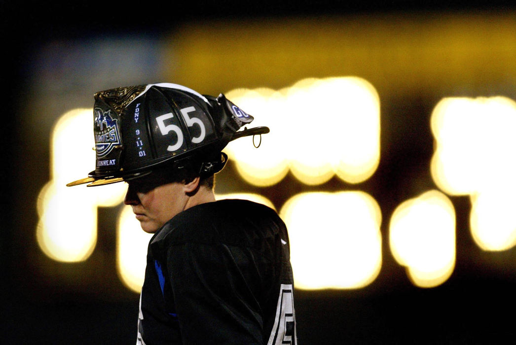 Third Place, Photographer of the Year - Fred Squillante / The Columbus DispatchSidelined for the season because of a back injury, the Flames' Laura Kerr stands on the sidelines during a game against the D.C. Divas. She wears a firefighter's helmet which has her number and the Columbus Flames logo on it. She is a firefighter from Fairborn. 