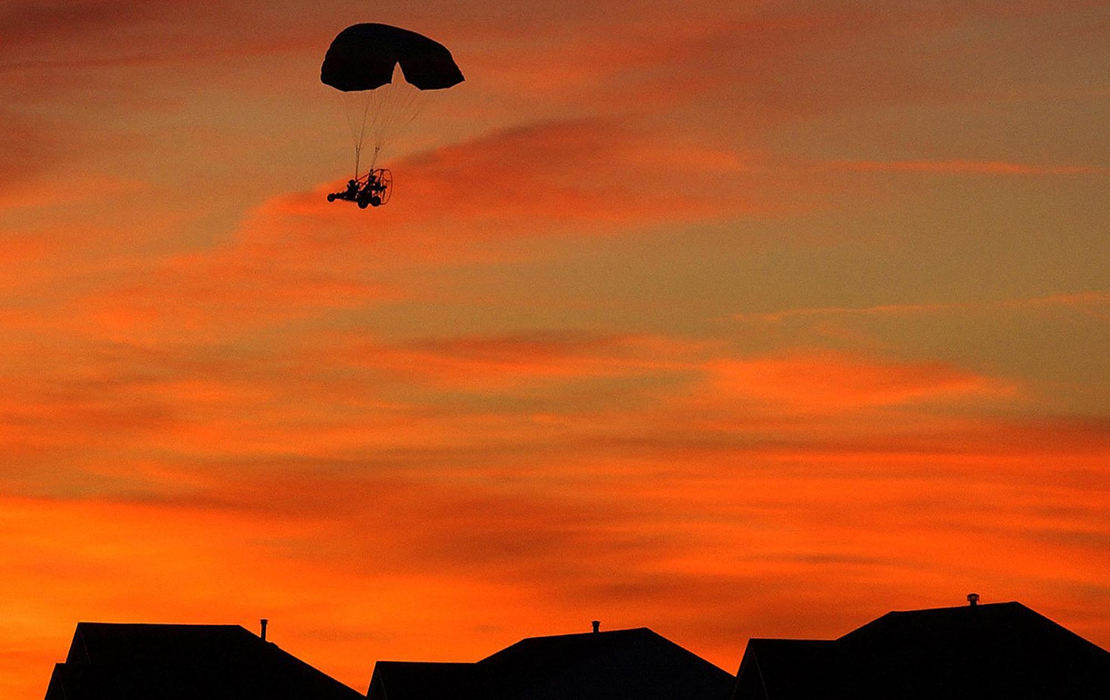 Award of Excellence, Photographer of the Year - Michael E. Keating / Cincinnati EnquirerGliding above the rooftops of nearby houses Richard Anderson makes his final approach to land his powered parachute vehicle nearby.  