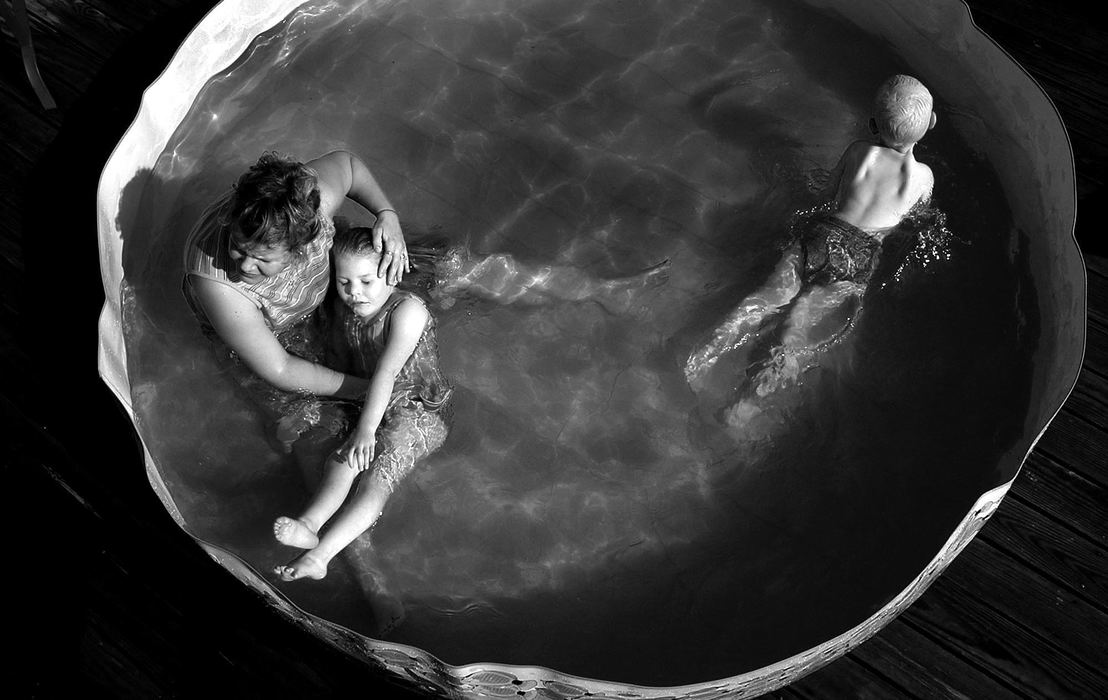 Award of Excellence, Photographer of the Year - Michael E. Keating / Cincinnati EnquirerAudrianna and her mother Melissa play in a backyard wading pool as her brother Noah joins them. She enjoyed the water, but paid a price with an infection from bacteria she ingested while swallowing water. Her gastric problems contributed to the complications she endured,