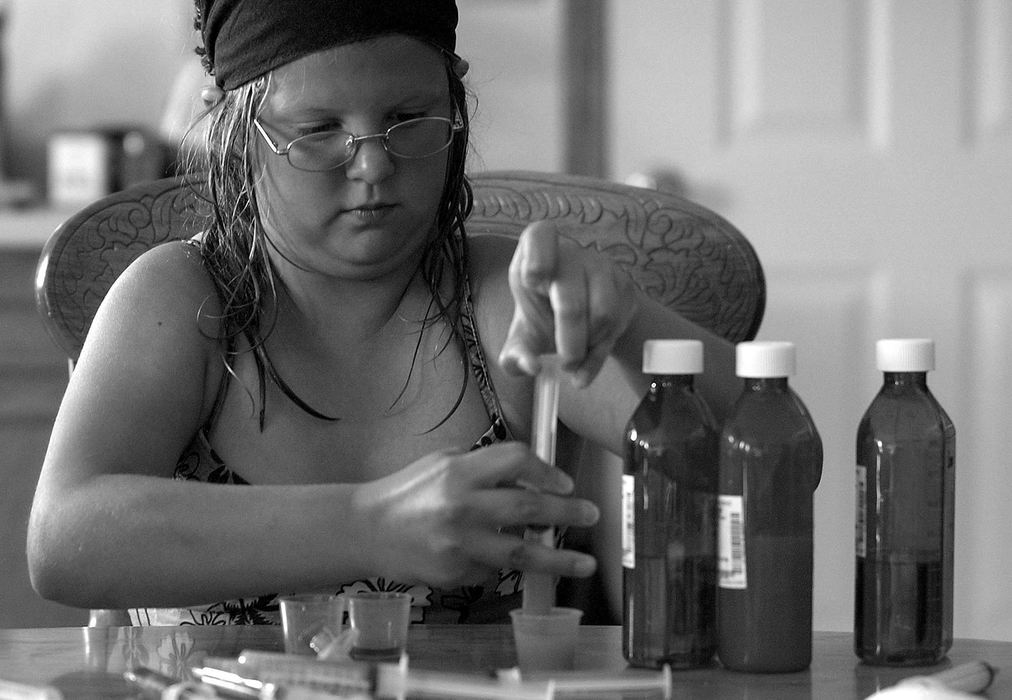 Award of Excellence, Photographer of the Year - Michael E. Keating / Cincinnati EnquirerAudrianna's big sister Amanda mixes medications that will be stored in the refrigerator until needed.  Audrianna is fed with a g-tube inserted in her stomach and receives medication with her feedings every two hours. Amanda does this to help her mother, a big responsibility for a 10-year-old.