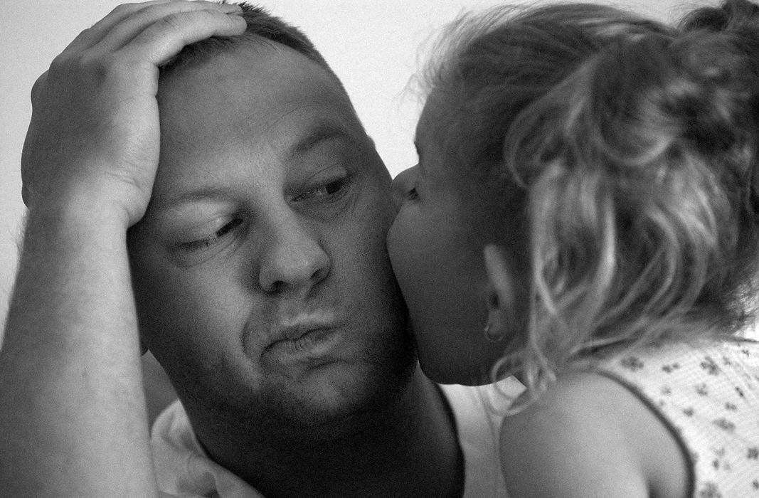 Award of Excellence, Photographer of the Year - Michael E. Keating / Cincinnati EnquirerRandy Hahn casts a wary eye toward his daughter who is kissing him. Audrianna sometimes will bite instead of kissing, often more like licking.  Randy works nearly 70 hours a week and is seldom charged with personal care issues for his daughter.