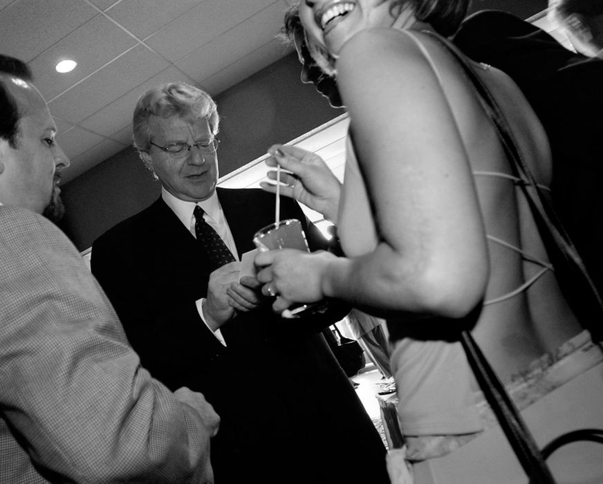 Award of Excellence, Photographer of the Year - Michael E. Keating / Cincinnati EnquirerSpringer's magnetism drew politicos as well as the curious. Here, a young woman flashes a smile to her friend with a camera as she stands near Springer for a keepsake photograph. "Just being close to him gives me a thrill", she said.